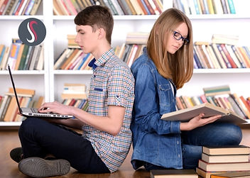 Deux élèves qui étudient sur un ordinateur et en lisant des livres